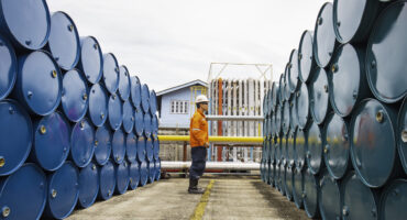 Male worker inspection record drum oil stock barrels blue and green horizontal or chemical for in the industry.